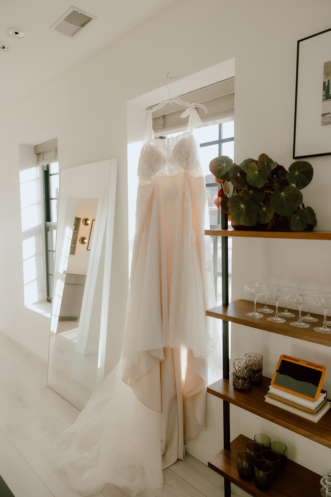 wedding dress hanging from a window 