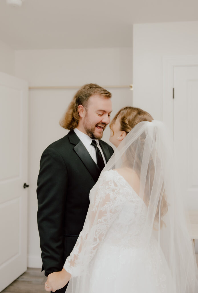 Couple standing looking at one another smiling.