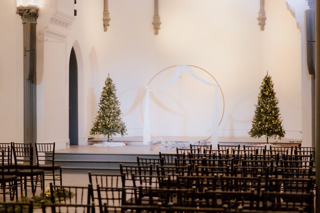 The ceremony space with chairs and Christmas trees. 