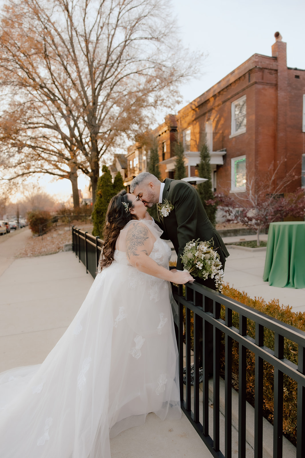 Groom kissing his bride over a fence